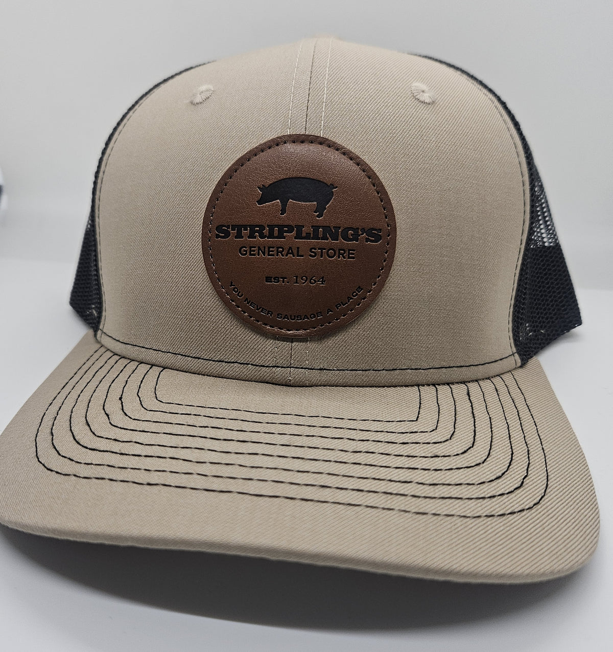 Stripling's khaki trucker hat with a round brown leather Stripling's General Store patch